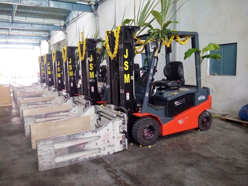 Row of JSM branded forklifts at a warehouse facility