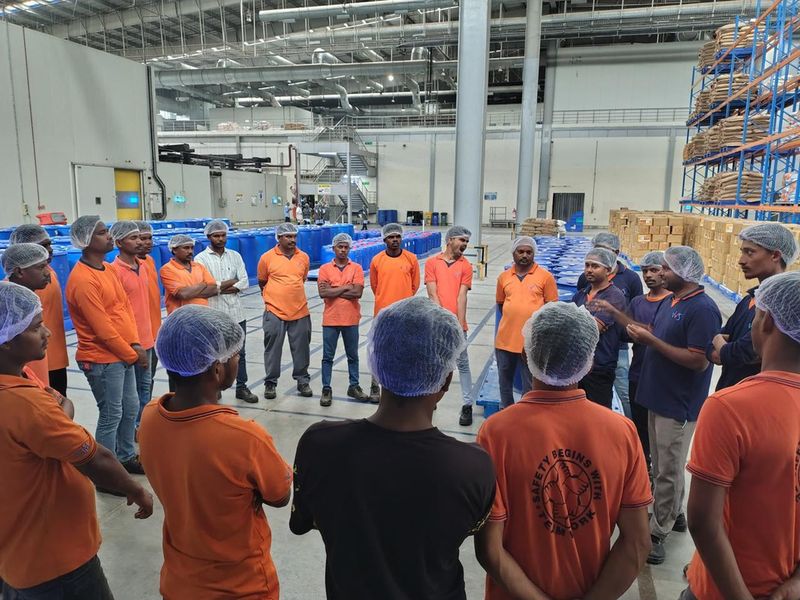 JSM warehouse team in uniform and safety gear at a modern facility